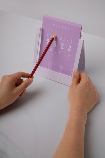 Mãos segurando maquete de calendário