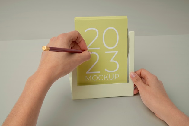 Mãos segurando maquete de calendário