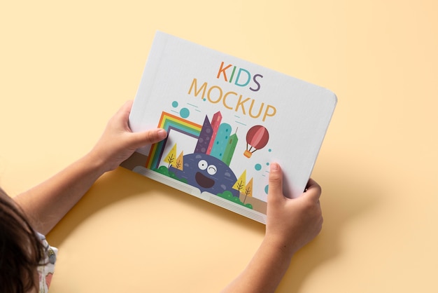 Mãos segurando maquete de livro infantil