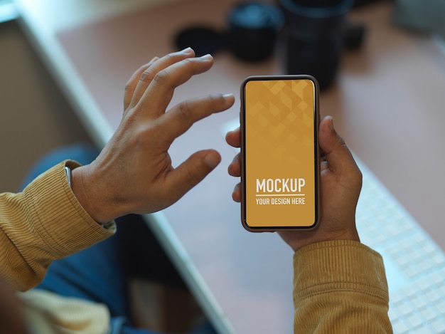 Mãos usando maquete de smartphone na mesa de trabalho