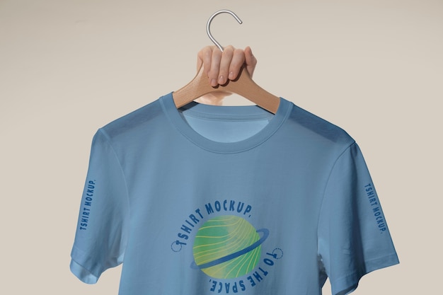 Maqueta de camiseta sostenida por mano humana