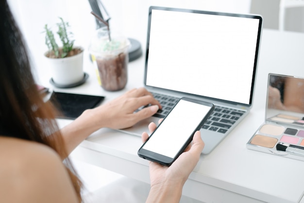 Maqueta de hermosa mujer de compras en línea con computadora portátil y teléfono inteligente en sitios web en línea