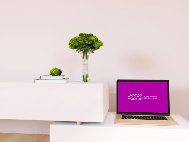 Maqueta de laptop en mesa con planta de flores y libro