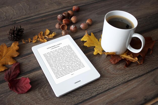 Maqueta de lector de libros electrónicos con hojas de otoño, castañas y café