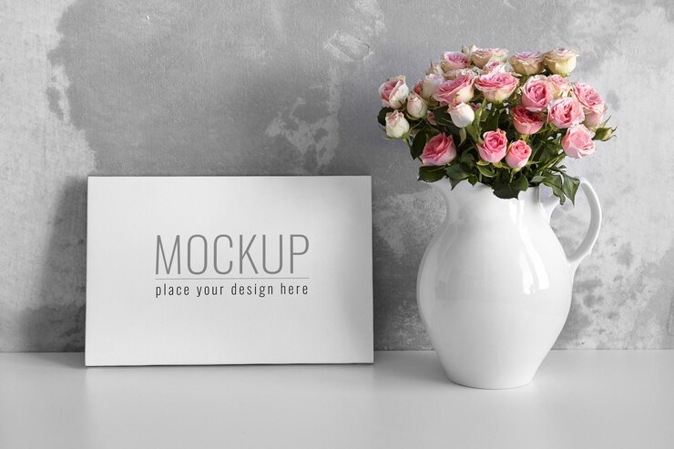 Maqueta de lienzo en blanco sobre mesa blanca con flores rosas en florero sobre fondo de pared de hormigón