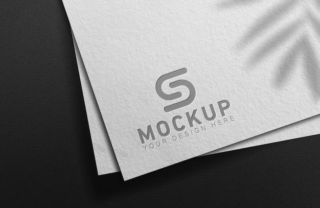 Maqueta de logotipo elegante en papel blanco sobre fondo negro