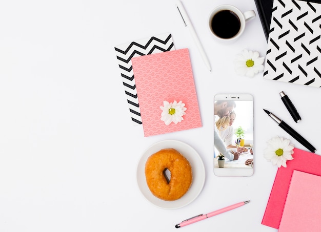 Maqueta de smartphone con desayuno en oficina