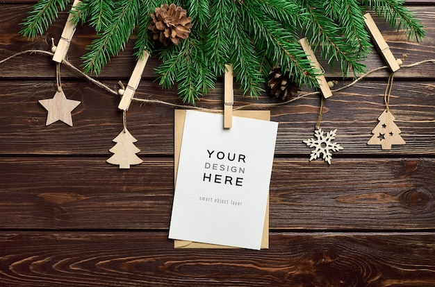 Maqueta de tarjeta de felicitación con adornos navideños de madera y ramas de abeto