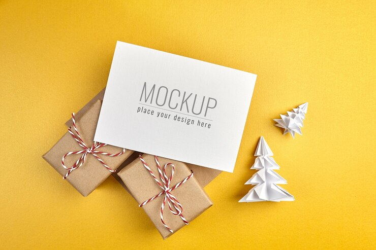Maqueta de tarjeta de felicitación con cajas de regalo y árboles de Navidad de papel sobre fondo dorado