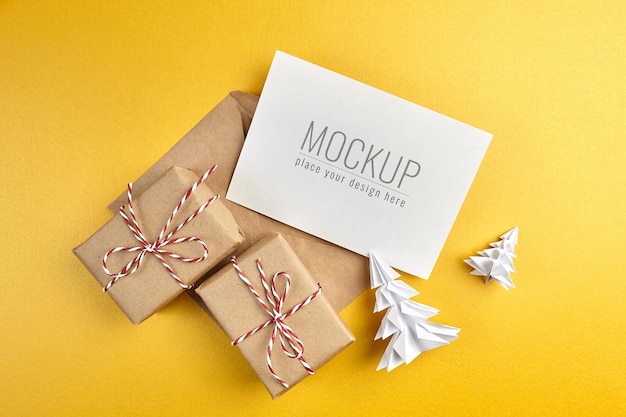 PSD maqueta de tarjeta de felicitación con cajas de regalo y árboles de navidad de papel