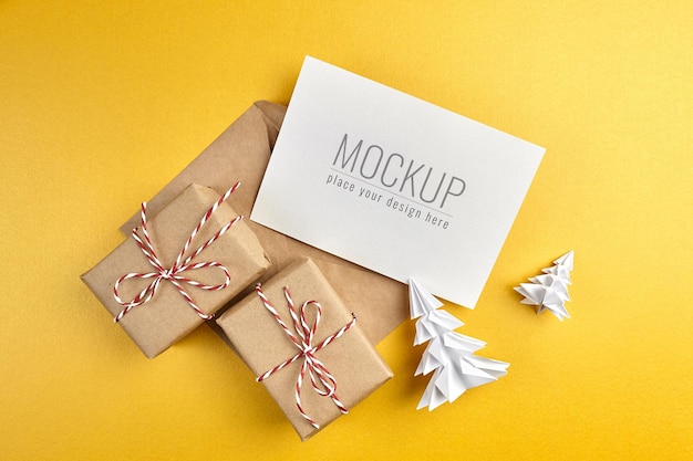 Maqueta de tarjeta de felicitación con cajas de regalo y árboles de Navidad de papel