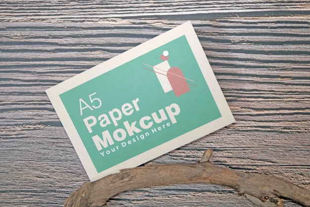 Maqueta de tarjeta de felicitación de papel A5 sobre fondo de madera