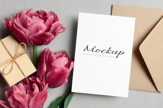 Maqueta de tarjeta de felicitación con sobre de caja de regalo y flores de tulipanes