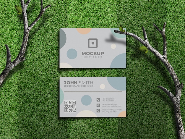 Maqueta de tarjeta de presentación en campo de hierba verde o césped con patrón de corte y ramas de árboles