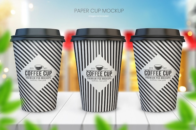 PSD maqueta de taza de café de papel realista de tres tazas con café borroso en el fondo