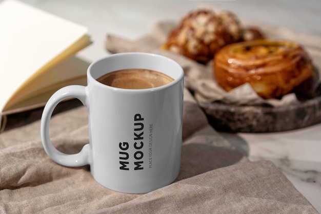 Maqueta de taza en una mesa con muffins