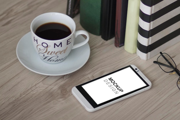 Maqueta de teléfono inteligente con cuaderno, café y biblioteca, hogar