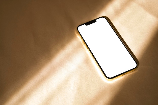 Maqueta de teléfono con sombras de luz solar sobre fondo beige