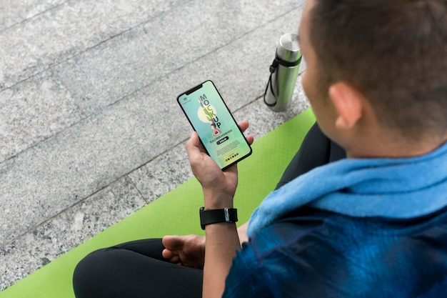 Maqueta de yoga con hombre sosteniendo teléfono inteligente