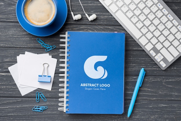 Maquete de caderno plana leigos e artigos de papelaria perto de café e teclado