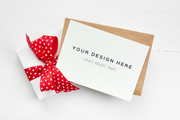PSD maquete de cartão de felicitações com envelope e caixa de presente com fita vermelha em branco