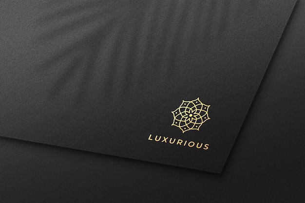 Maquete de logotipo de folha de ouro de luxo em papel preto
