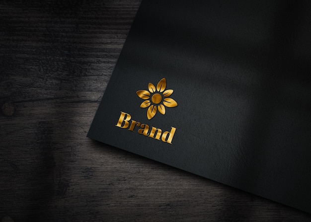 Maquete de logotipo dourado em relevo em papel preto PSD Premium