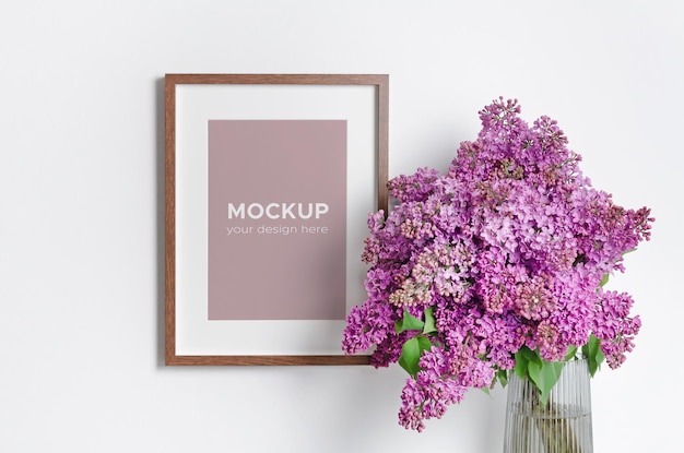 PSD maquete de moldura de retrato na parede branca com grande buquê de flores lilás