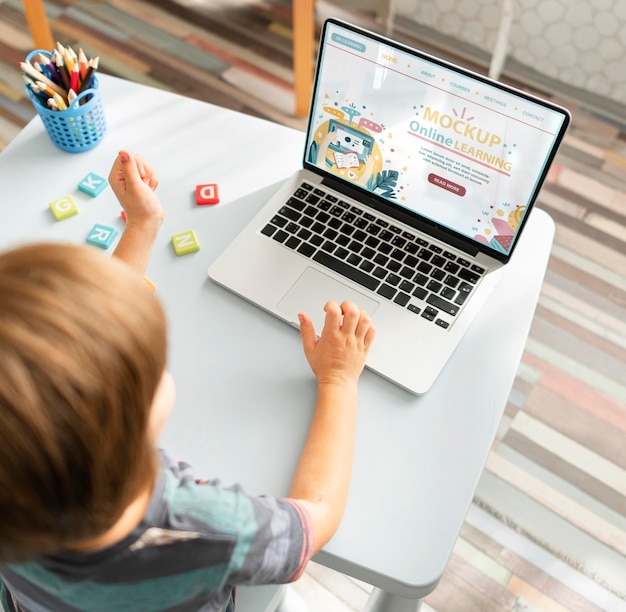 PSD maquete de sala de aula virtual com criança, mesa e dispositivo