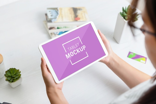 Maquete de tablet branco nas mãos de mulheres
