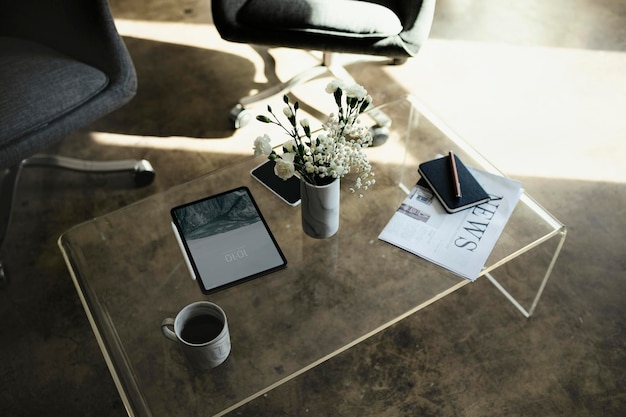 Maquete de tablet digital por um vaso com flores de cravo brancas