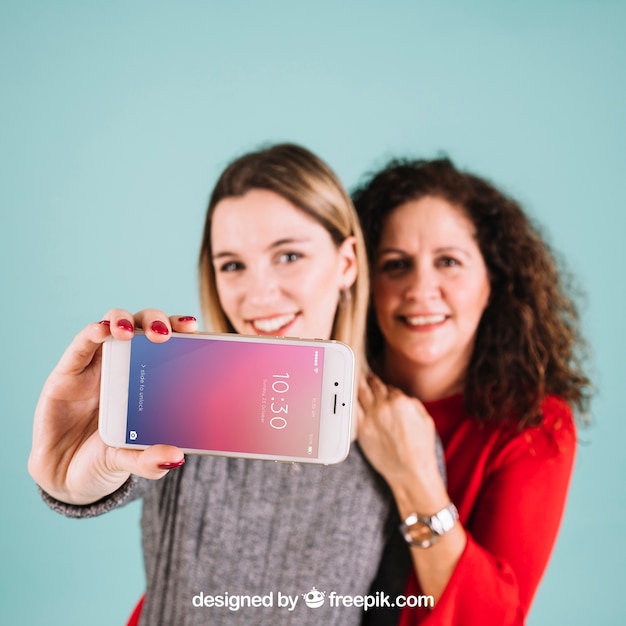 Maquete de tecnologia com mulheres apresentando smartphone