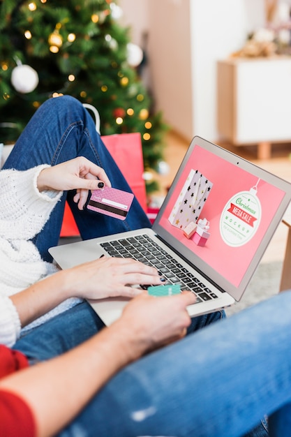 PSD maquete de venda de natal com mulher usando laptop