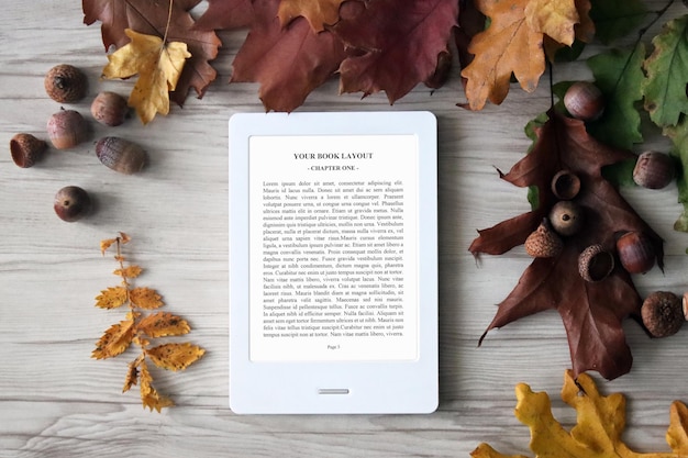Maquete do leitor de e-book com folhas de outono, castanhas no fundo colorido