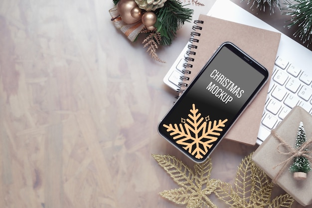 Maquete do smartphone na mesa do escritório em casa para plano de fundo de Natal e ano novo
