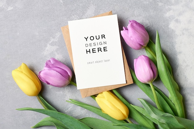 Maquette de carte de voeux avec enveloppe et fleurs de tulipes sur fond gris
