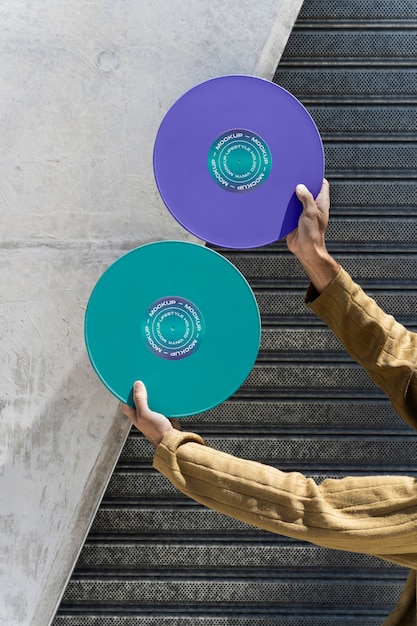 PSD maquette de disque vinyle tenue à la main