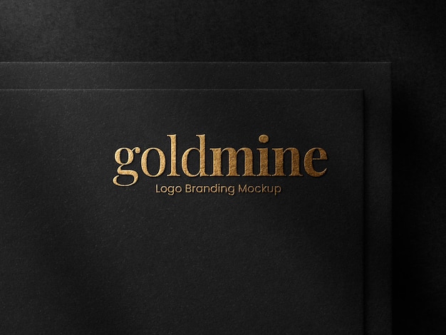 Maquette de logo en relief de feuille d'or de luxe sur papier noir