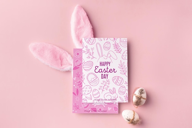 Maquette de Pâques avec affiche décorative d'oreilles de lapin et d'oeufs sur fond rose
