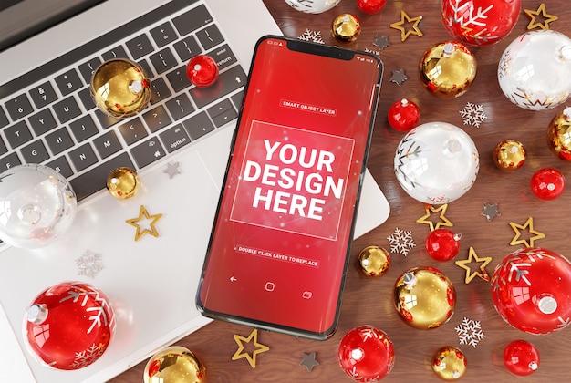 PSD une maquette de smartphone sur le bureau avec un ordinateur portable et des boules de noël