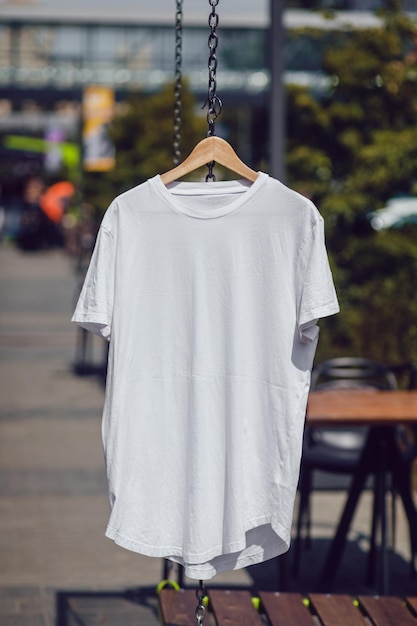 Une maquette de T-shirt blanc accrochée à l'extérieur