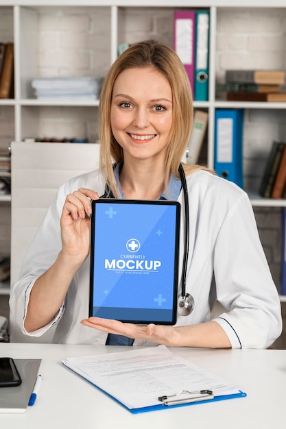 Médecin souriant à plan moyen avec tablette