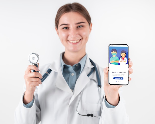 Medico donna che tiene uno smartphone mock-up