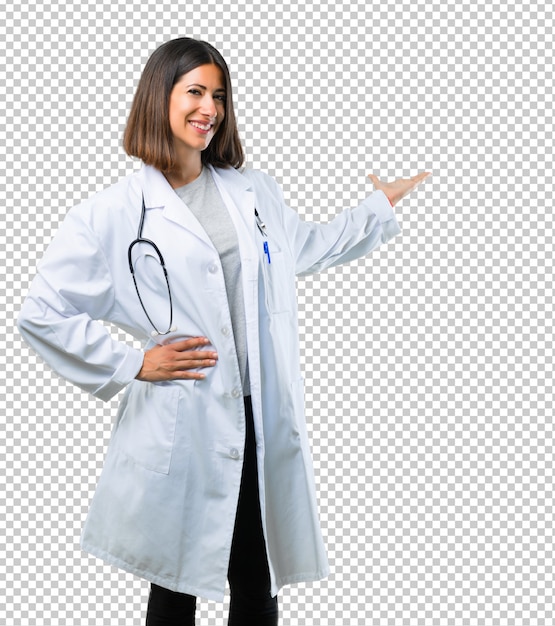 Médico mujer con estetoscopio apuntando hacia atrás con el dedo índice presentando un producto
