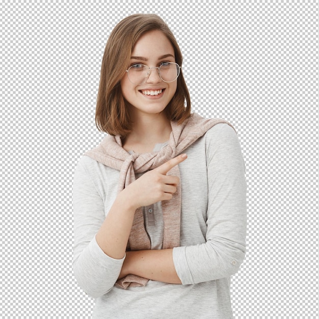 Melhor espaço de cópia que você já viu feliz despreocupada bela jovem com cabelo curto castanho em óculos e camisola amarrada sobre o pescoço sorrindo amigável apontando para a direita dirigindo para um lugar legal