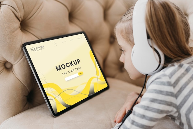 Menina com tablet no sofá