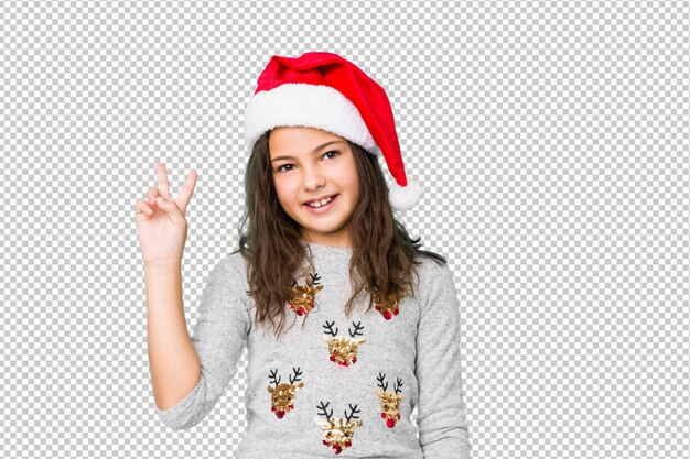 Menina comemorando o dia de Natal alegre e despreocupada, mostrando um símbolo de paz com os dedos.