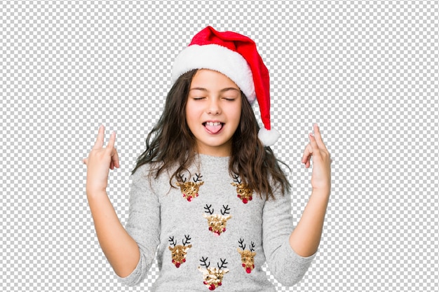 Menina comemorando o dia de natal, mostrando o gesto de pedra com os dedos