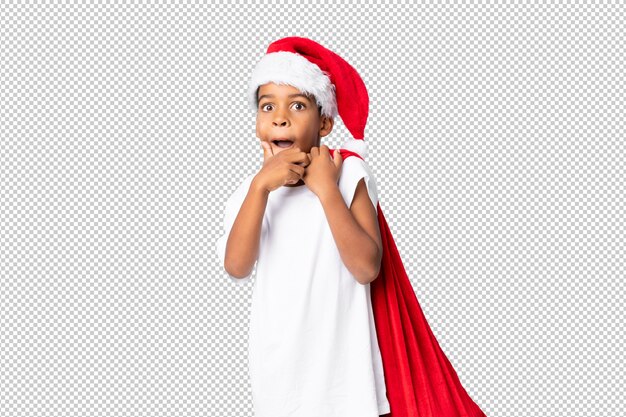 Menino afro-americano com chapéu de natal e levar uma sacola com presentes