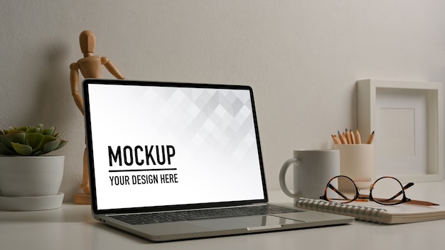 Mesa de trabalho com maquete de laptop, óculos e decorações na sala de home office